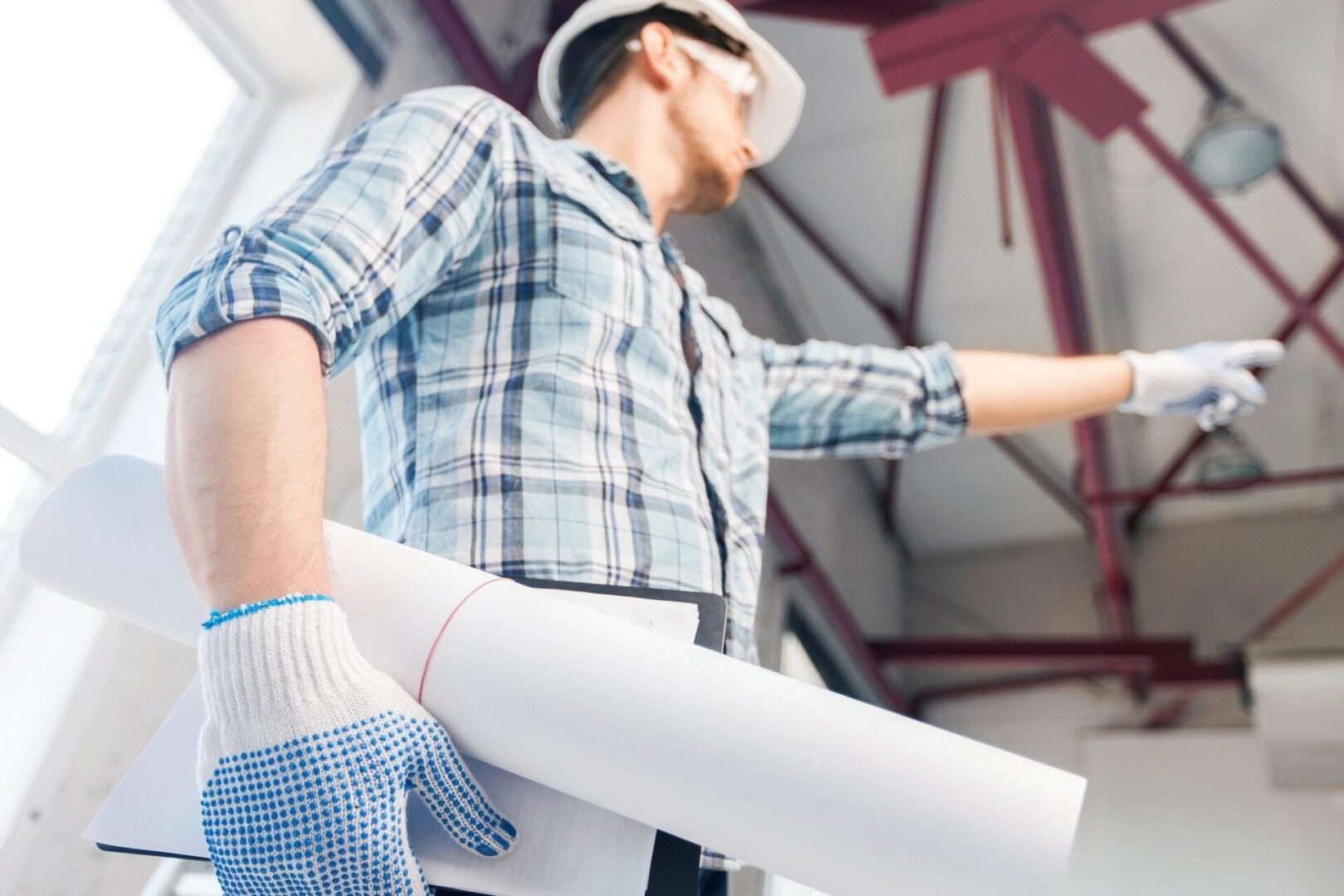 A man in plaid shirt holding construction paper.