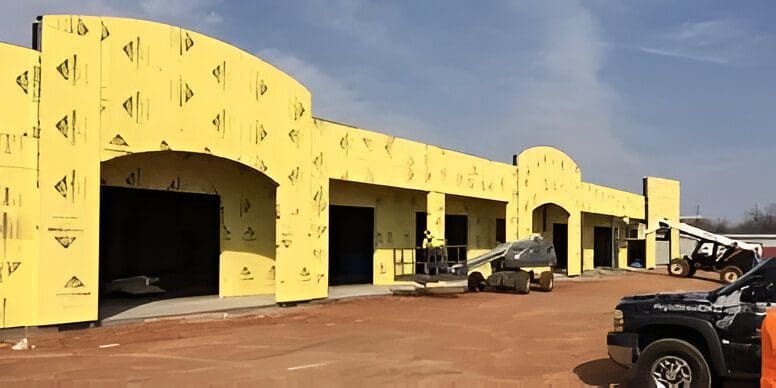 A car parked in front of a building under construction.