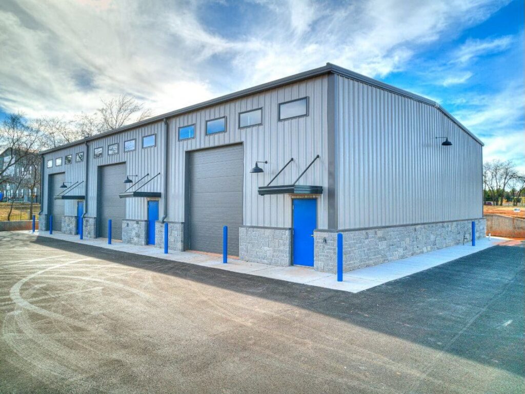 Large steel warehouse with blue roll-up doors built by Rigid Building Group